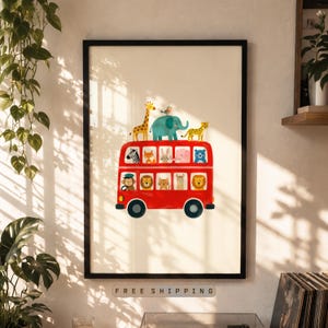 May include: A framed print featuring a red double-decker bus filled with various cartoon animals. A giraffe, elephant, and cheetah are on top. The print has a white background and a black frame. The text "FREE SHIPPING" is at the bottom.