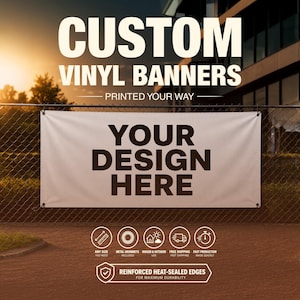 May include: White vinyl banner with the text "YOUR DESIGN HERE" in bold black letters. The banner is hanging on a chain-link fence. The top of the banner reads "CUSTOM VINYL BANNERS PRINTED YOUR WAY".