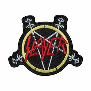 May include: Embroidered patch featuring the word "SLAYER" in red, stylized lettering, set against a white pentagram within a yellow circle. The patch is black with decorative elements around the edges.