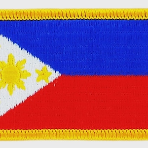 May include: Embroidered patch featuring the flag of the Philippines. The design includes a blue upper section, a red lower section, a white triangle with a yellow sun and stars, and a yellow border.