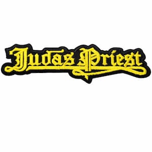 May include: Embroidered patch featuring the band name "Judas Priest" in yellow, stylized lettering with a black border. The patch is rectangular and designed for application on clothing or accessories.