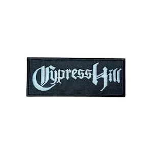 May include: A rectangular black patch with the words "Cypress Hill" embroidered in a stylized, light blue font. The patch is likely for clothing or accessories, showcasing the band's name.