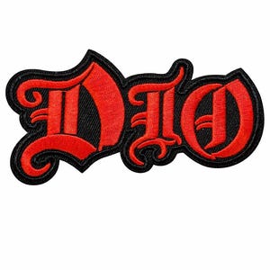 May include: Embroidered patch featuring the word "DIO" in bold, red gothic lettering. The letters are outlined in black, creating a striking contrast against the white background. This patch is likely for a band or music merchandise.