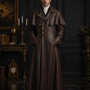 May include: A long, brown leather coat with a double-breasted design and a cape-like shoulder detail. The coat features gold-coloured buttons and a high collar. The person is wearing a white cravat. The coat appears to be a vintage or historical style.
