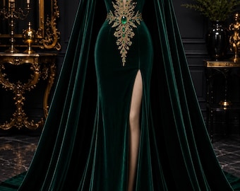 Puede incluir: Un vestido largo de terciopelo verde oscuro con un escote en V profundo, bordados dorados y detalles de piedras preciosas verdes. El vestido incluye una capa con capucha incorporada, un corpiño ajustado y una abertura lateral alta en el muslo.