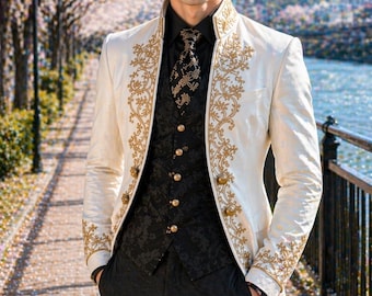 May include: A cream-colored long coat with gold embroidery, worn over a black vest and pants. The coat features ornate gold detailing along the edges and sleeves. The outfit includes a black shirt and patterned tie. The ensemble is formal and elegant.