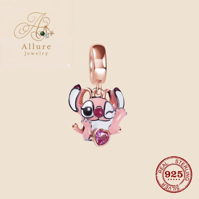 Op de afbeelding: Een ros&eacute;gouden bedel met een roze en wit stripfiguur dat knipoogt en een hartvormige edelsteen vasthoudt. De bedel is van Allure Jewelry en is gemaakt van 925 sterling zilver.