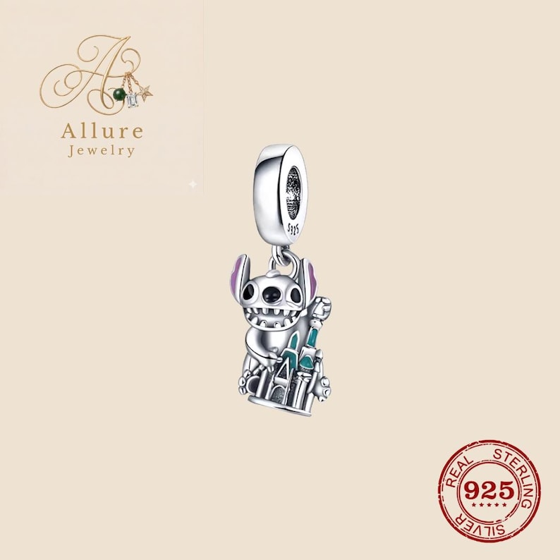 Op de afbeelding: Een zilveren bedel met een stripfiguur met paarse oren en een kasteel. De bedel is gemarkeerd met "925" en "Real Sterling Silver". De bedel is van Allure Jewelry.