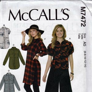 May include: McCall's M7472 sewing pattern envelope featuring illustrations of five shirt variations and photographs of two outfits. One outfit shows a red and black plaid long shirt with leggings, and the other shows a black floral blouse with wide-leg pants.
