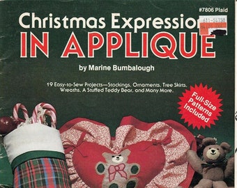 May include: A book cover with the title "Christmas Expression in Applique" by Marine Bumbalough. The cover features a red heart-shaped pillow with a teddy bear applique, a plaid stocking with a teddy bear applique, and several teddy bears.
