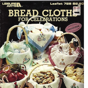 May include: A leaflet cover featuring various bread cloths for celebrations. The cloths are displayed in wicker baskets, each with a different embroidered design. The designs include bunnies, bears, and festive characters. The text "BREAD CLOTH FOR CELEBRATIONS" is prominently displayed.