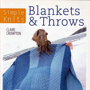 May include: A book cover titled "Blankets & Throws" with the author's name, Claire Crompton. The cover features a person holding a blue knitted blanket. The book also says "Simple Knits" and "10 great designs to choose from".
