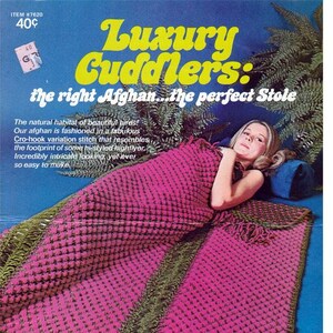 May include: A pink and green crocheted afghan with fringe. The afghan is folded in half and a person is lying on top of it. The text on the cover reads "Luxury Cuddlers: the right Afghan...the perfect Stole".