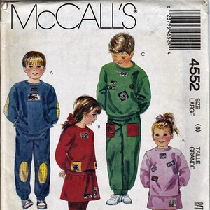 May include: A sewing pattern for children's clothing. The pattern includes three designs: a blue sweatshirt with yellow accents, a green sweatshirt with red accents, and a pink sweatshirt with white accents. The pattern is for size 8, and is called "Focus on Overlock (Serger) Sewing".