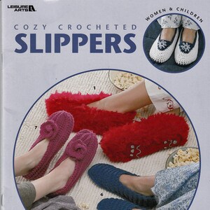 May include: Cozy crocheted slippers in various colors and styles, including red fuzzy slippers, pink slippers with a flower detail, and blue slippers. The image also shows a pair of white crocheted slippers with a flower detail.