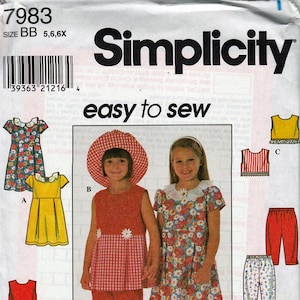 May include: Simplicity sewing pattern featuring children's clothing designs. The cover shows two girls wearing dresses and outfits. The pattern includes options for dresses, tops, and pants. The text "easy to sew" is displayed.
