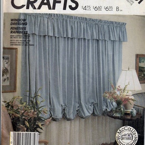 May include: A sewing pattern for window dressing, featuring a blue and white balloon valance. The pattern is from McCall's Crafts and is labeled 2861. The pattern is for making curtains, shades, and valances.