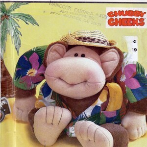 May include: Simplicity crafts pattern featuring a plush monkey wearing a straw hat and Hawaiian shirt. The monkey has a large, smiling face and is holding a banana. The pattern is labeled "Chubby Cheeks."