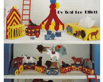 May include: A craft leaflet titled "Under the Big Top in Plastic Canvas" featuring various circus-themed plastic canvas projects. The projects include a circus tent, animals, a carousel, and a train. The leaflet is by Teal Lee Elliott.