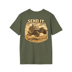 May include: Olive green t-shirt featuring a graphic of a skeleton driving a jeep with the text "SEND IT" above the jeep. The jeep is jumping in a desert landscape.
