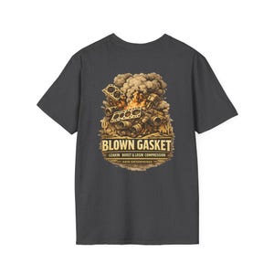May include: Dark gray t-shirt featuring a graphic of an engine with a blown gasket, flames, and smoke. The text "BLOWN GASKET" is above "LEAKIN BOOST & LOSIN COMPRESSION" and "ARID ENTERPRISES".