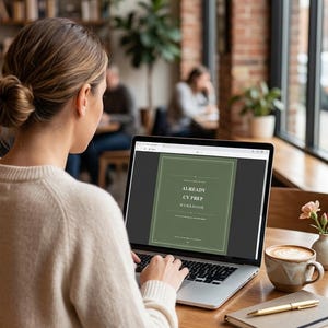 Peut inclure: Un ordinateur portable affiche un document intitulé "AI-READY CV PREP WORKBOOK" sur une table en bois. Une tasse de café, un carnet et un stylo sont à proximité. La scène se déroule dans un café.