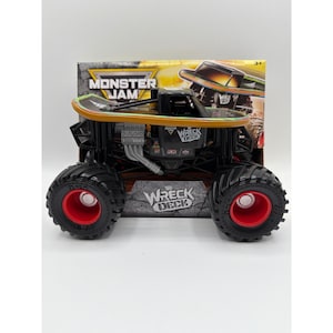 May include: A Monster Jam Wreck Deck monster truck toy featuring a black body with a skateboard-style top, silver engine details, and large black tires with red rims. The packaging displays the Monster Jam logo and the Wreck Deck name.