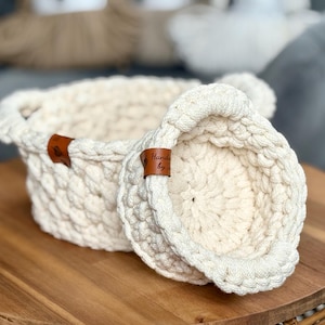 Op de afbeelding: Een set van drie keramische mokken met een gespikkelde, matte afwerking. De mokken zijn in crème, lichtgrijs en donkergrijs. Elke mok heeft een eenvoudig, minimalistisch ontwerp.