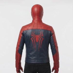 K&ouml;nnte beinhalten: Rote und marineblaue Lederjacke mit einem Spinnenemblem auf dem R&uuml;cken. Die Jacke hat eine Kapuze und Handschuhe mit einem spinnennetzartigen Muster auf den Schultern. Das Design ist von einem Superheldenkost&uuml;m inspiriert.