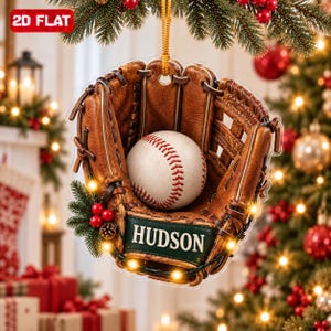 Peut inclure: Une décoration de Noël plate à suspendre en forme de gant de baseball en cuir marron tenant une balle de baseball blanche avec des coutures rouges. Le gant présente un écusson rectangulaire vert foncé avec le nom HUDSON en lettres blanches.