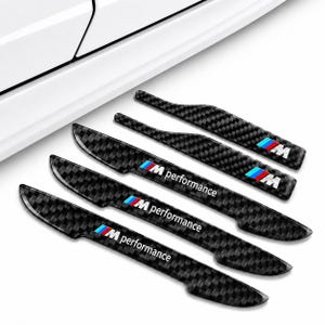 Puede incluir: Juego de cinco pegatinas negras de fibra de carbono para manijas de puertas de automóviles. Cada pegatina tiene el texto "M performance" en blanco, con el logotipo de BMW M en azul, rojo y blanco.
