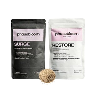 May include: Two stand-up pouches labelled phasebloom, one black labelled SURGE and one white labelled RESTORE, featuring text about hormone regulation, plant protein, and antioxidants, with a small pile of light brown seeds centred in the foreground.
