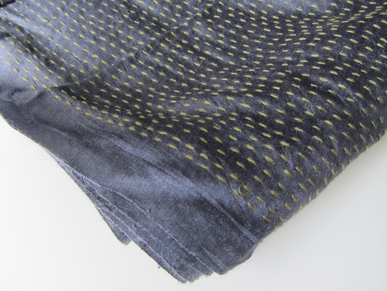 Peut inclure: Un tissu gris fonc&eacute; avec une texture subtile. Le tissu pr&eacute;sente un motif de petites coutures jaunes qui cr&eacute;ent un effet de points.