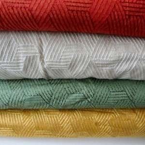 May include: Four fabric swatches with a geometric pattern. The swatches are stacked on top of each other. The top swatch is red, the second is beige, the third is green, and the bottom swatch is yellow.