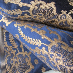 May include: Blue fabric with a gold damask pattern. The fabric is folded in half, showing the pattern on both sides.