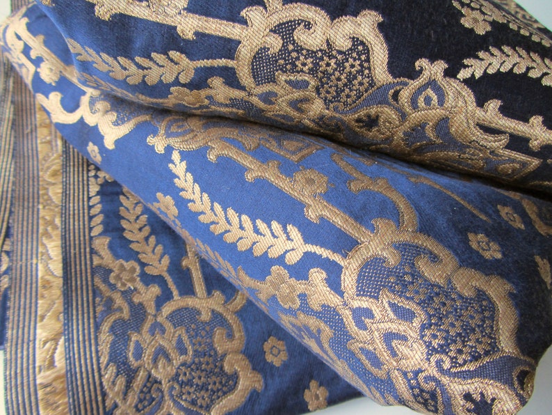 May include: Blue fabric with a gold damask pattern. The fabric is folded in half, showing the pattern on both sides.