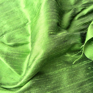 May include: A close-up of a green fabric with a subtle sheen and a textured, woven appearance.