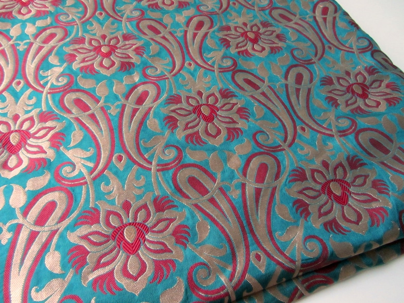 K&ouml;nnte beinhalten: T&uuml;rkisfarbener Stoff mit Paisley- und Blumenmuster in Gold und Rot.
