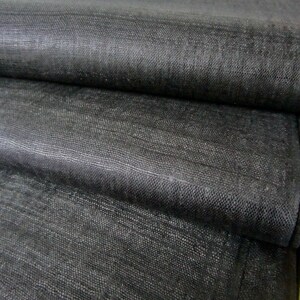 May include: Black linen fabric folded in layers, showing the texture and weave of the material.