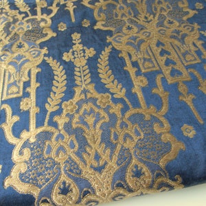 May include: Blue fabric with a gold damask pattern. The pattern features intricate floral designs and repeating motifs.
