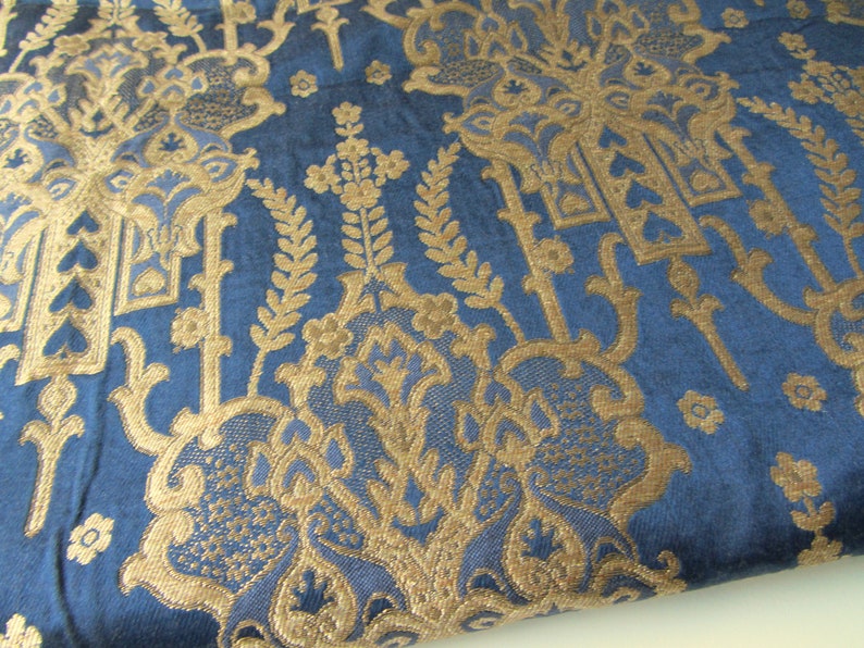 May include: Blue fabric with a gold damask pattern. The pattern features intricate floral designs and repeating motifs.