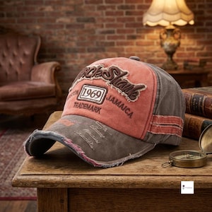 Puede incluir: Una gorra de béisbol desgastada con un panel frontal color coral y texto bordado en marrón que dice Uncle Shane, 1969, Trademark y Jamaica. La gorra tiene una visera y paneles laterales marrones con bordes deshilachados y aspecto vintage.