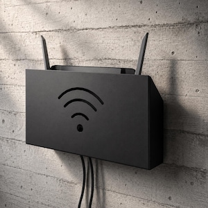 May include: A matte black wall-mounted router enclosure featuring a cutout Wi-Fi signal icon on the front panel. The rectangular metal housing includes two vertical antennas extending from the top and two black cables exiting from the bottom.