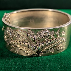Sterlingzilveren Victoriaanse armband gedateerd 1884, met aangebrachte varens en bloemen in wassing met goud