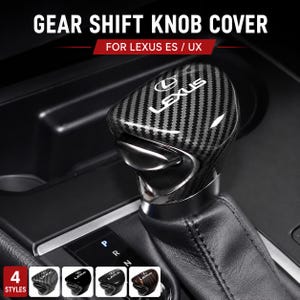 May include: A carbon fiber gear shift knob cover for Lexus ES/UX vehicles. The cover features the Lexus logo and comes in four styles. The image shows the gear shift knob in a car interior.