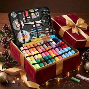May include: A red velvet sewing kit with a gold ribbon, open to reveal spools of colorful thread, scissors, needles, and other sewing supplies. A black zippered case holds additional tools. A gift box with a gold bow is in the background.