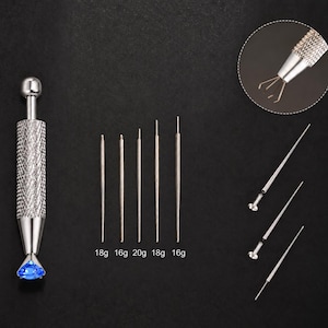May include: A silver-toned metal prong tool with a textured grip and a ball-end handle, featuring a blue gemstone held by four prongs. Includes five interchangeable needle-like attachments labelled 18g, 16g, 20g, 18g, and 16g, plus a circular inset view.
