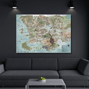 Könnte beinhalten: Ein detaillierter Karten-Druck, der eine Fantasy-Welt darstellt, mit Landmassen in Grün-, Braun- und Beigetönen, umgeben von blauem Wasser. Die Karte ist an einer Wand über einem grauen Sofa angebracht. Zwei Scheinwerfer beleuchten das Kunstwerk.