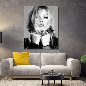 May include: A black and white photographic wall art print featuring a portrait of a person with long hair partially covering their face, wearing a dark collared jacket, with hands positioned near the chin, displayed in a rectangular frame.