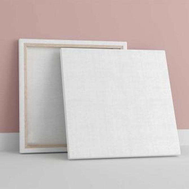 a white picture frame on the floor next to a pink wall